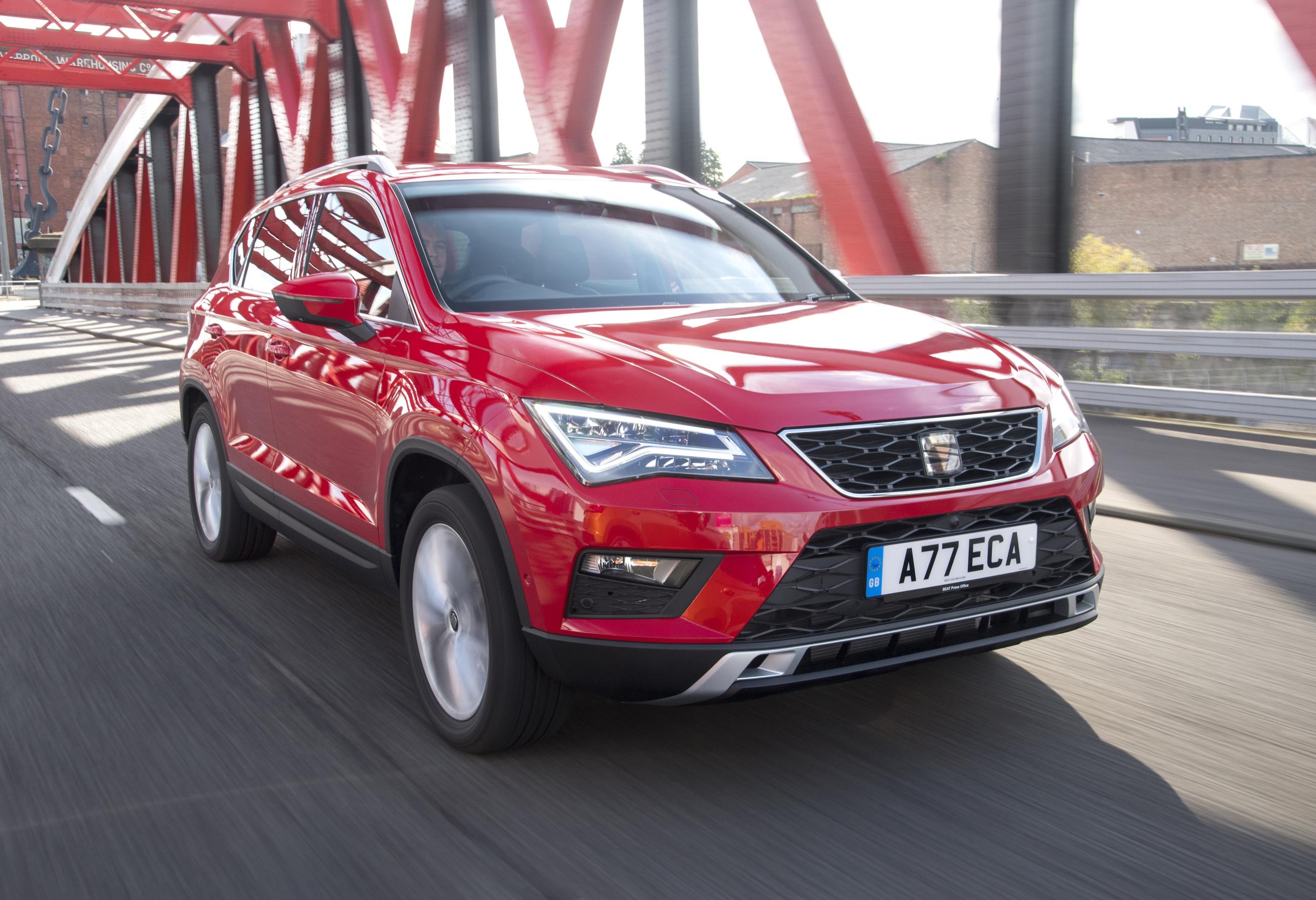 Red SEAT Ateca driving over a red suspension bridge